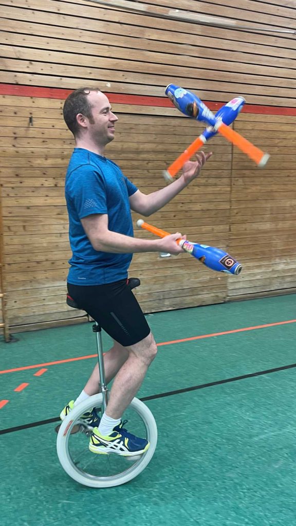 Akrobatik mit Einrad und Jonglier-Keulen